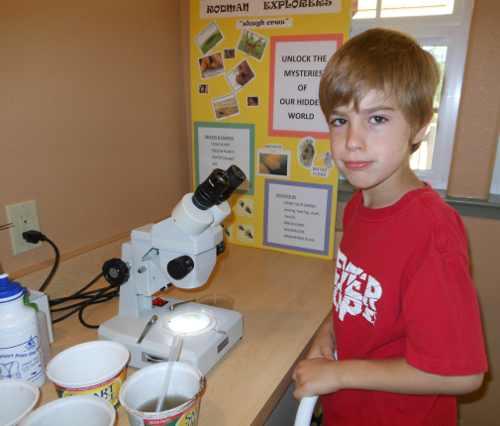 The children’s nature education program at the Rodman Preserve offers unique learning opportunities for young people. Here, Colby Smith works with a microscope. Courtesy photo. colbysmithrodmanexplorers