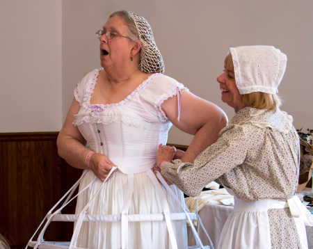 Barbara White struggles into a corset with the aid of Linda Lake. Courtesy photo. barbarawhitecorset